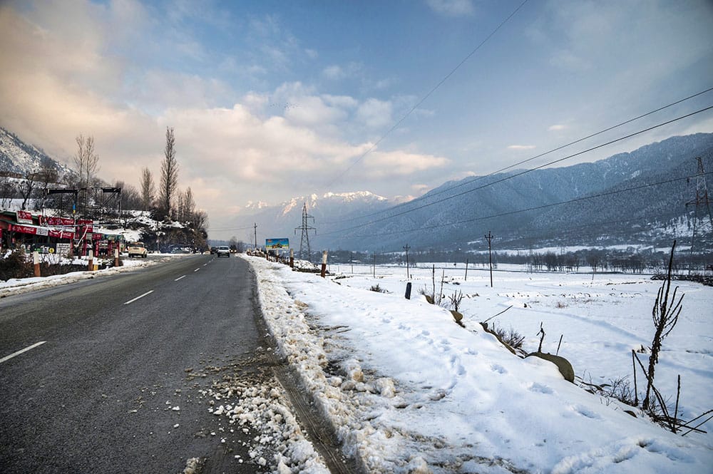 Snow-lined Srinagar–Leh highway with Himalayan mountain views — Kashmir group road trip for 7 people