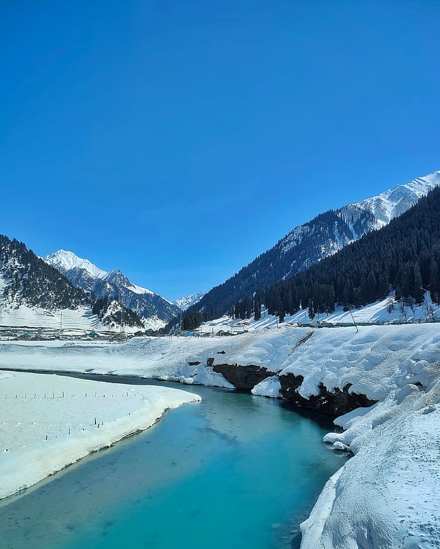 Turquoise river winding through a snow-covered Kashmir valley — Kashmir Deluxe Tour with houseboat